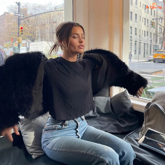 A black faux fox fur coat for women with a shawl collar, batwing sleeves, and short streetwear cut for warm and stylish winter fashion.