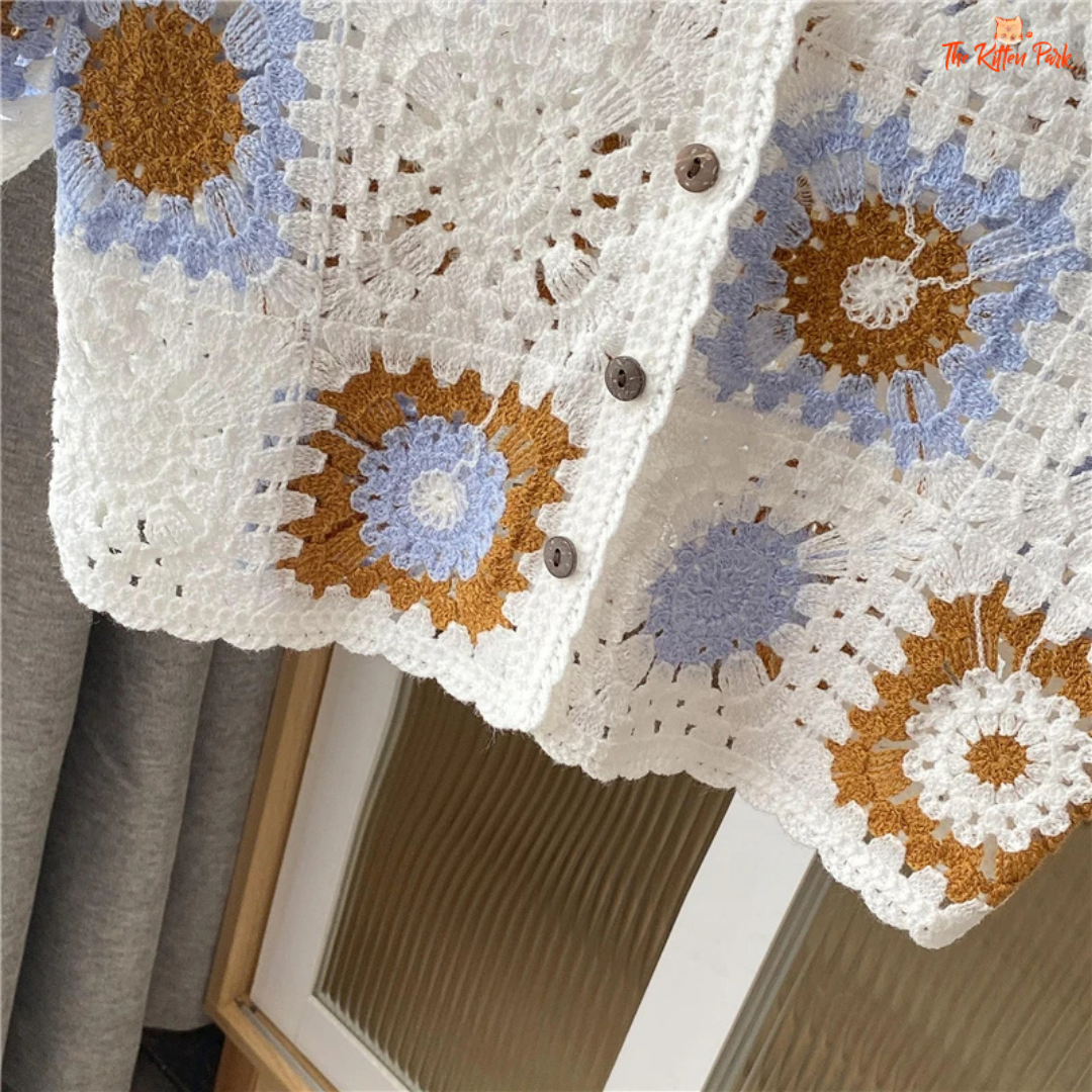 Sheer crochet cardigan featuring a colorful granny square pattern, collared crop cut, and button-up front for a boho summer look.