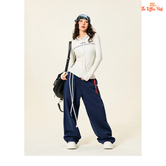 High-waisted vintage hip-hop sweatpants for women in navy blue with wide legs, drawstring waist, and bandage-style design. Autumn/winter streetwear look.