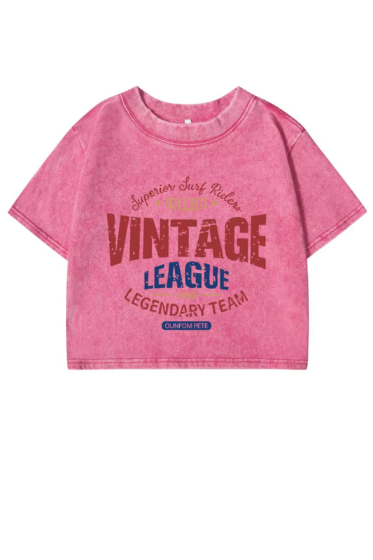 Women’s vintage cotton crop top with distressed finish and cartoon-style league letter prints in washed tones.