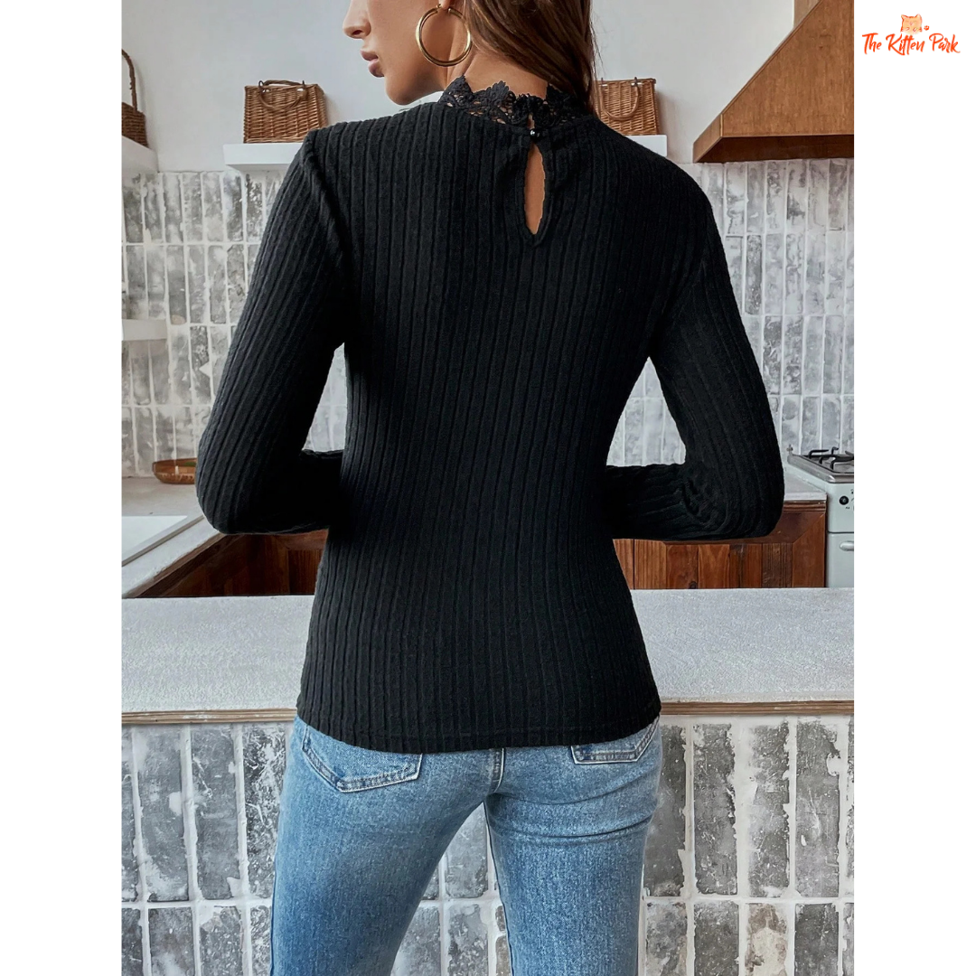Person wearing a black ribbed sweater with a cut-out design in a kitchen setting