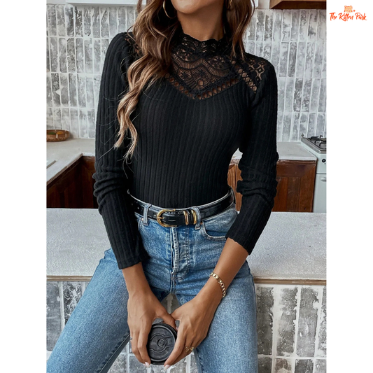 Woman wearing a black ribbed sweater with lace details and blue jeans in a kitchen.