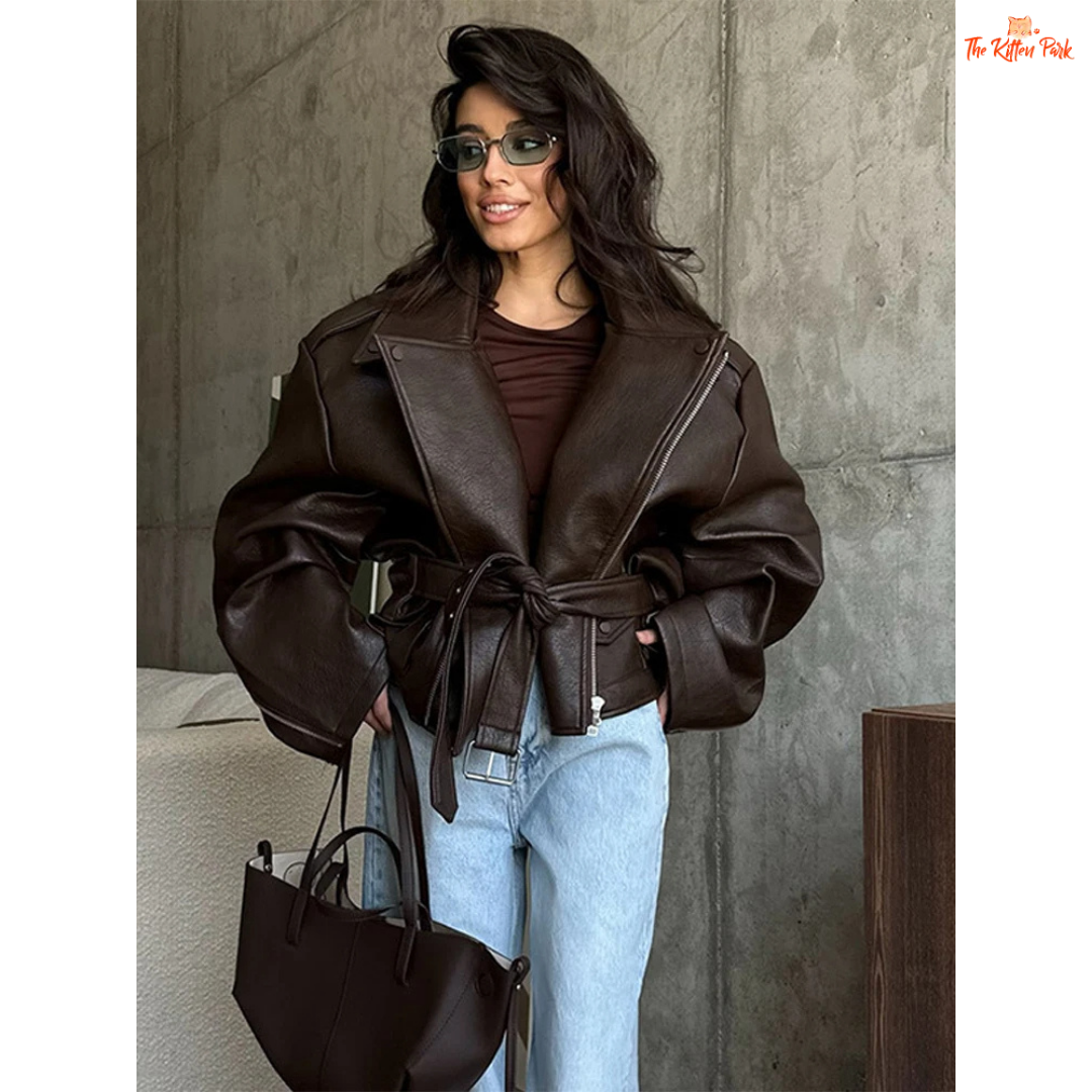 Women's brown faux leather belted biker jacket with lace-up waist, puff sleeves, and zipper closure. Perfect for autumn/winter office style.