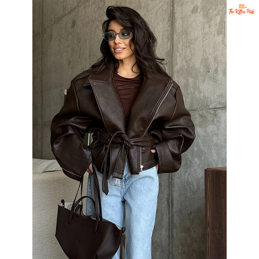 Women's brown faux leather belted biker jacket with lace-up waist, puff sleeves, and zipper closure. Perfect for autumn/winter office style.