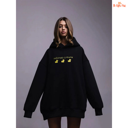 A women’s oversized fleece hoodie with a playful three-duck print, hooded collar, and drop shoulders, designed for autumn and winter casual wear.
