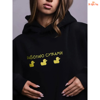 A women’s oversized fleece hoodie with a playful three-duck print, hooded collar, and drop shoulders, designed for autumn and winter casual wear.