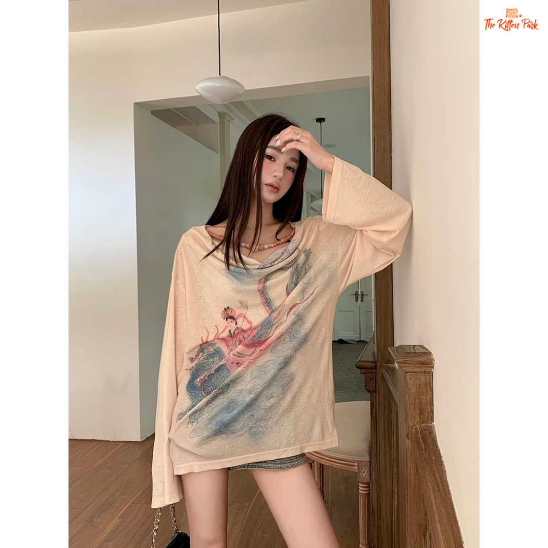 Long beige knit tee for women featuring a cowl neckline, hand-painted print, beaded accents, and a loose fit for stylish autumn layering.