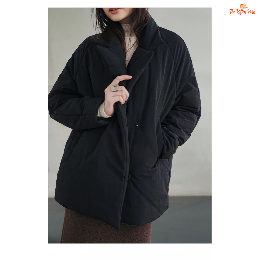A black cotton-padded puffer coat for women with a collared design, thick warmth, covered button full opening, polyester fiber filling, and regular loose streetwear fit.