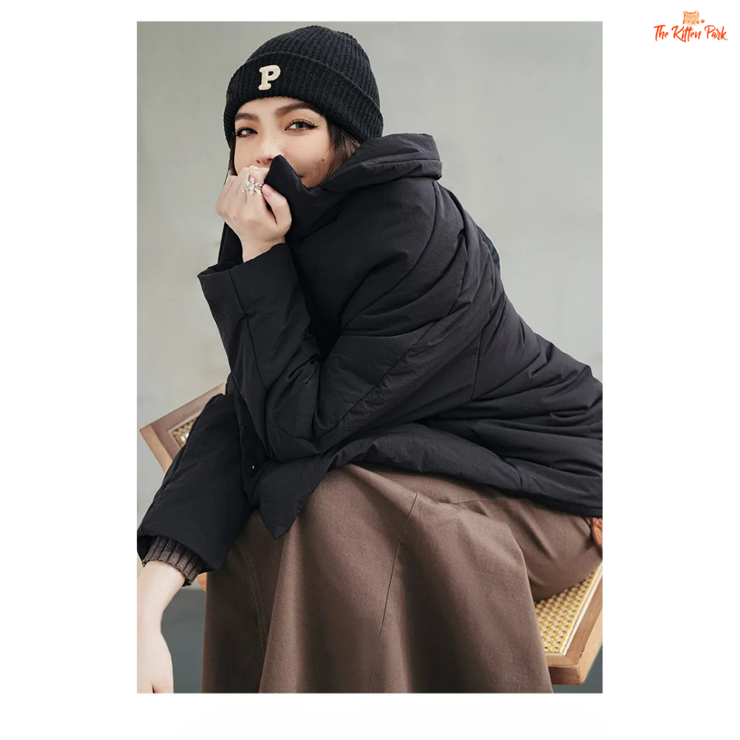 A black cotton-padded puffer coat for women with a collared design, thick warmth, covered button full opening, polyester fiber filling, and regular loose streetwear fit.