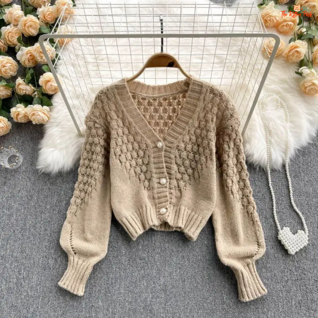 A loose-fit women’s knit cardigan with lantern sleeves, V-neck, hollow-out detailing, and single-breasted closure, designed for autumn/winter 2026.