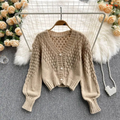 A loose-fit women’s knit cardigan with lantern sleeves, V-neck, hollow-out detailing, and single-breasted closure, designed for autumn/winter 2026.