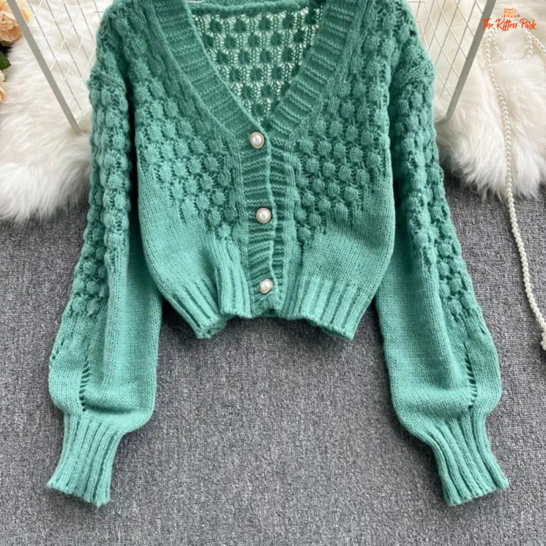 A loose-fit women’s knit cardigan with lantern sleeves, V-neck, hollow-out detailing, and single-breasted closure, designed for autumn/winter 2026.