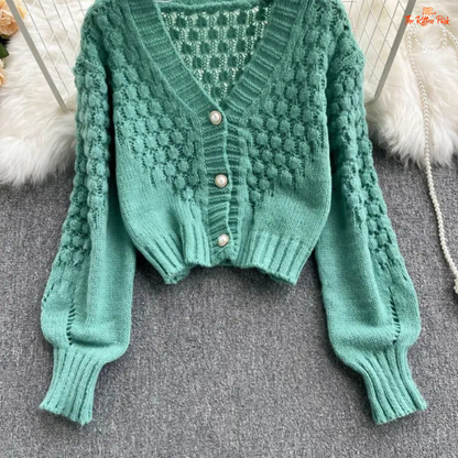 A loose-fit women’s knit cardigan with lantern sleeves, V-neck, hollow-out detailing, and single-breasted closure, designed for autumn/winter 2026.