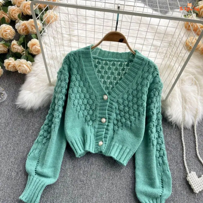 A loose-fit women’s knit cardigan with lantern sleeves, V-neck, hollow-out detailing, and single-breasted closure, designed for autumn/winter 2026.