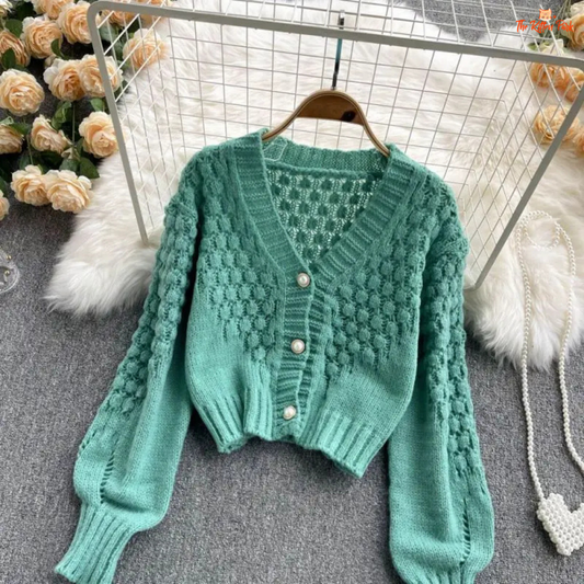 A loose-fit women’s knit cardigan with lantern sleeves, V-neck, hollow-out detailing, and single-breasted closure, designed for autumn/winter 2026.