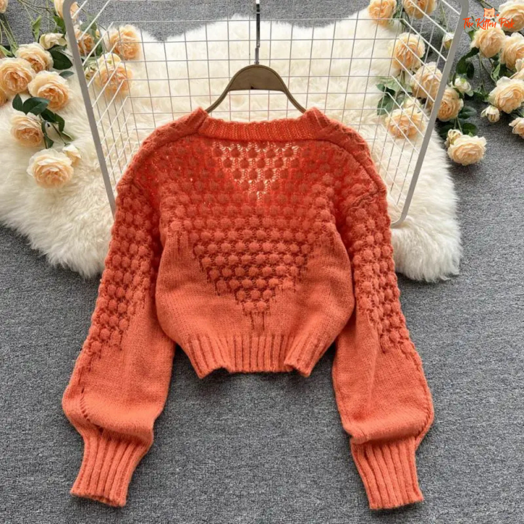 A loose-fit women’s knit cardigan with lantern sleeves, V-neck, hollow-out detailing, and single-breasted closure, designed for autumn/winter 2026.