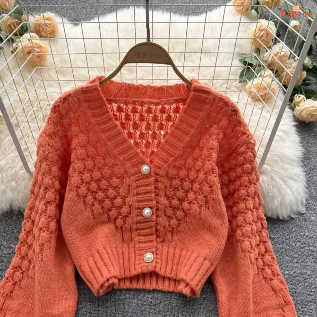 A loose-fit women’s knit cardigan with lantern sleeves, V-neck, hollow-out detailing, and single-breasted closure, designed for autumn/winter 2026.