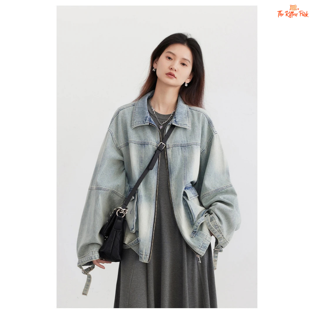 A women’s loose blue denim jacket made of cotton, featuring a turn-down collar, zipper closure, full sleeves, and pockets for a casual spring/autumn look.