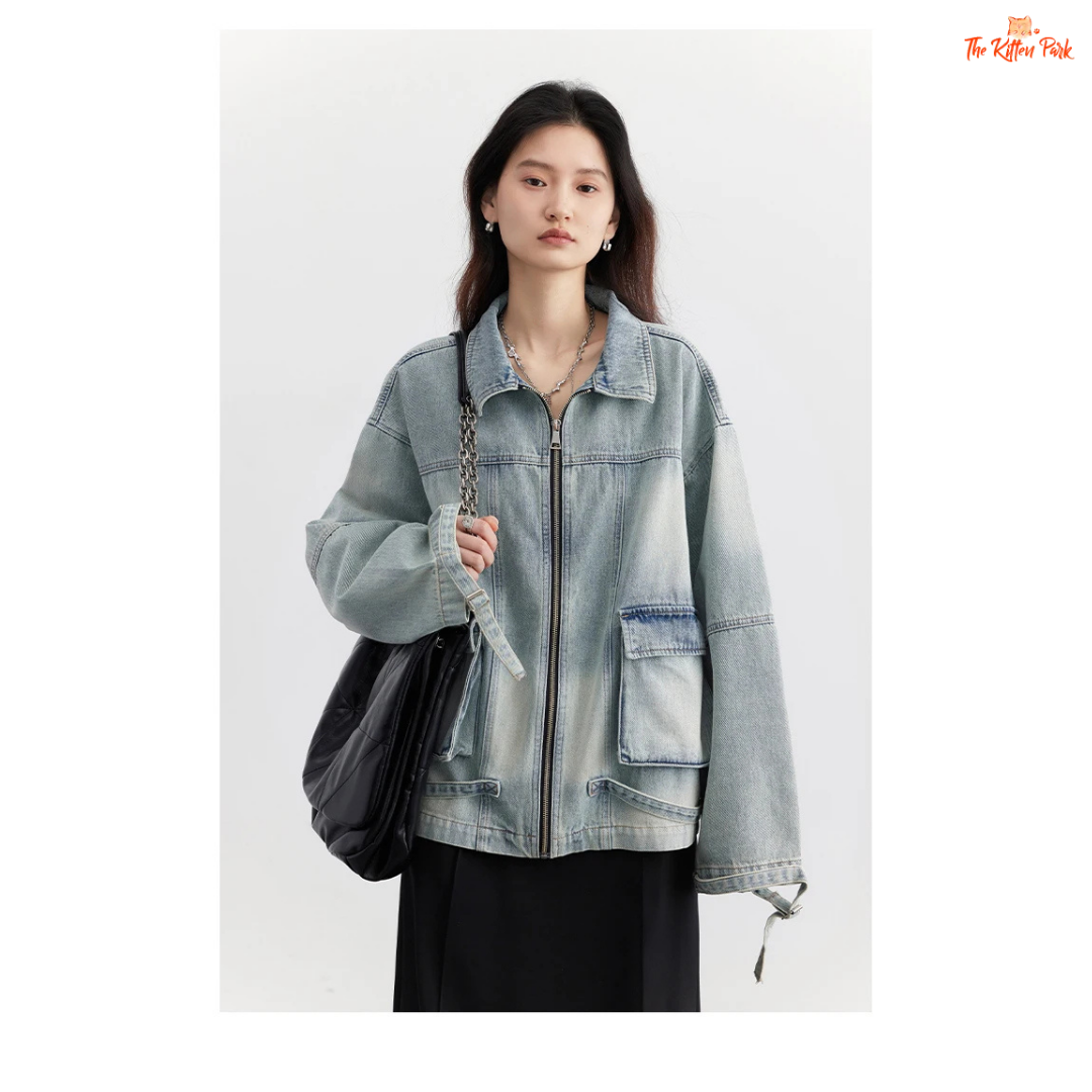 A women’s loose blue denim jacket made of cotton, featuring a turn-down collar, zipper closure, full sleeves, and pockets for a casual spring/autumn look.