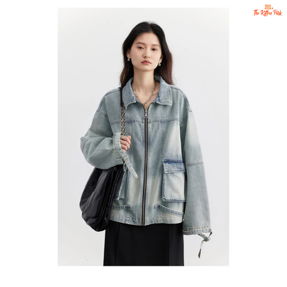 A women’s loose blue denim jacket made of cotton, featuring a turn-down collar, zipper closure, full sleeves, and pockets for a casual spring/autumn look.