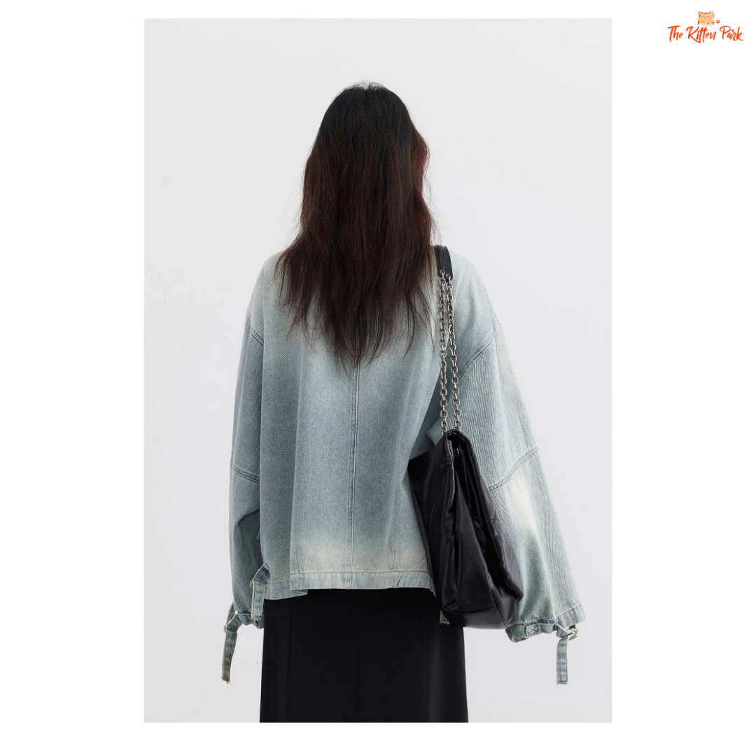 A women’s loose blue denim jacket made of cotton, featuring a turn-down collar, zipper closure, full sleeves, and pockets for a casual spring/autumn look.