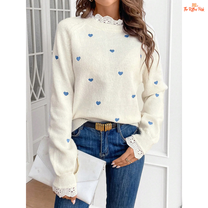 A soft ivory knit pullover featuring lace-trim heart embroidery, round neck, and regular fit for an elegant autumn-winter look.