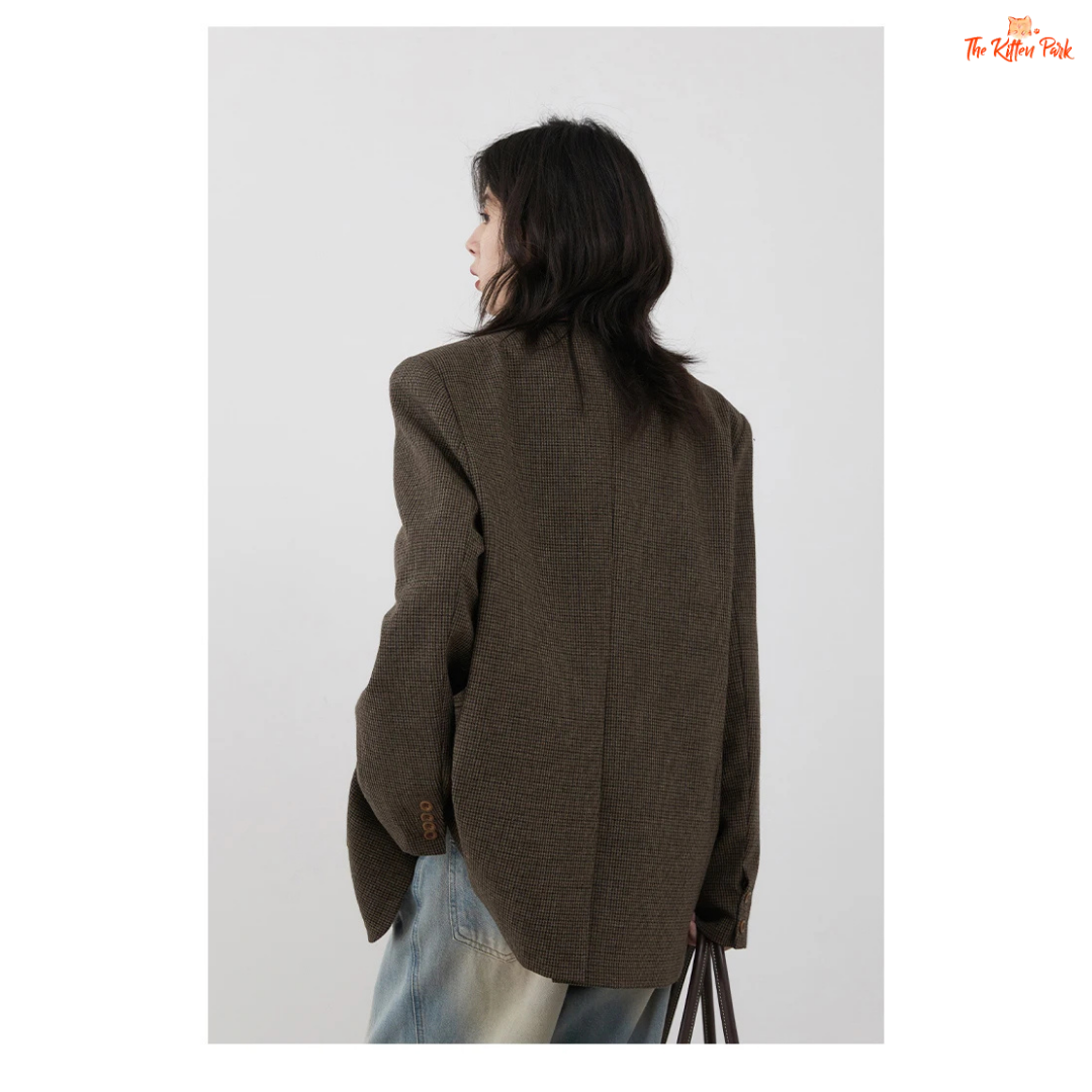 Person wearing a brown blazer against a white background