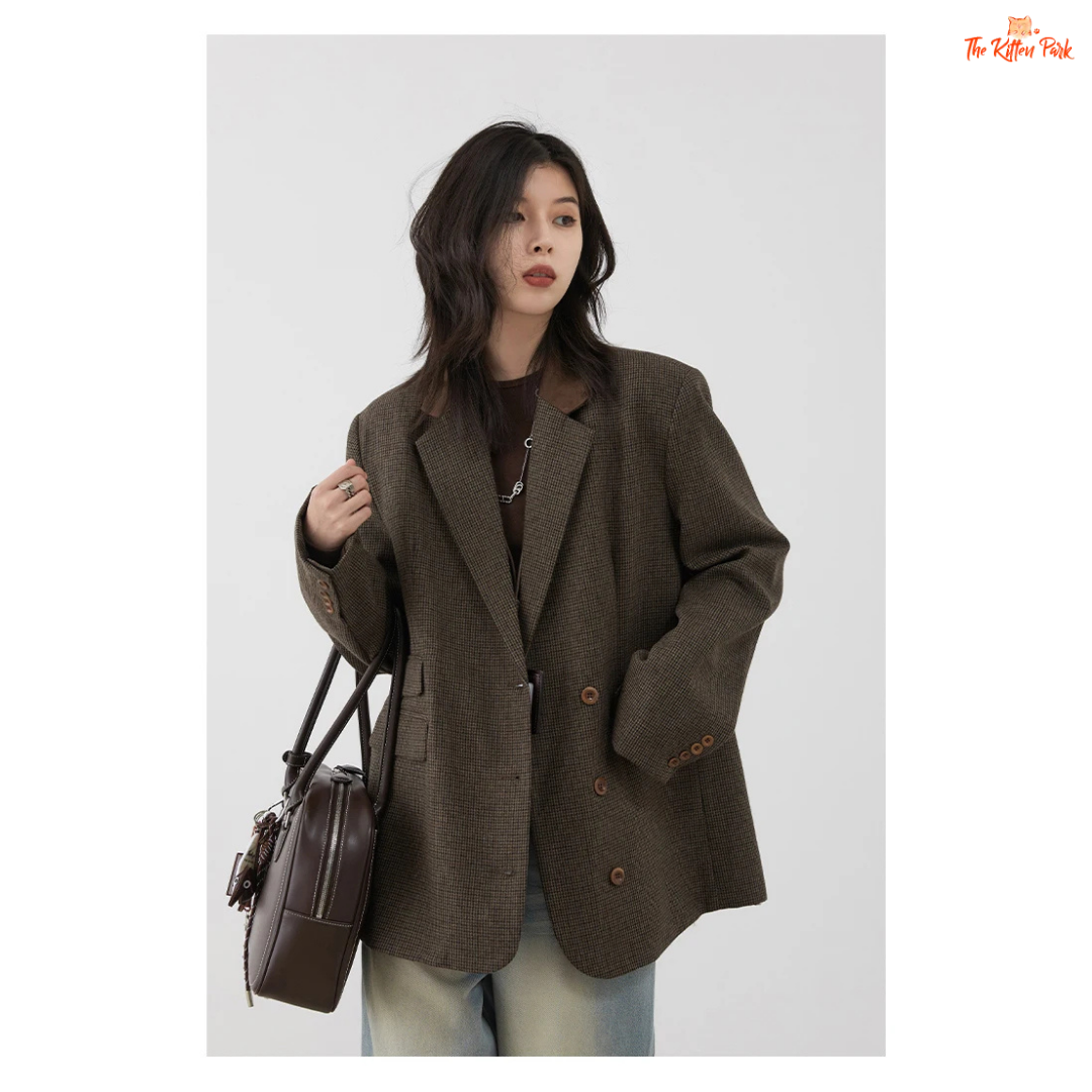 Woman wearing a brown blazer holding a brown bag against a white background