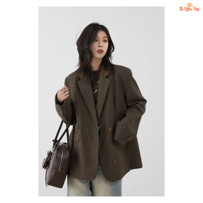 Woman wearing a brown blazer holding a brown bag against a white background