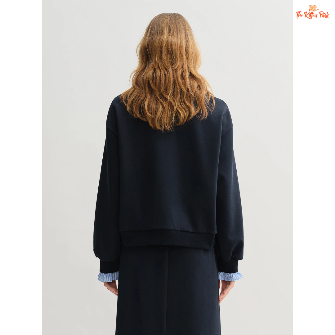 Person wearing a navy outfit with a plain background