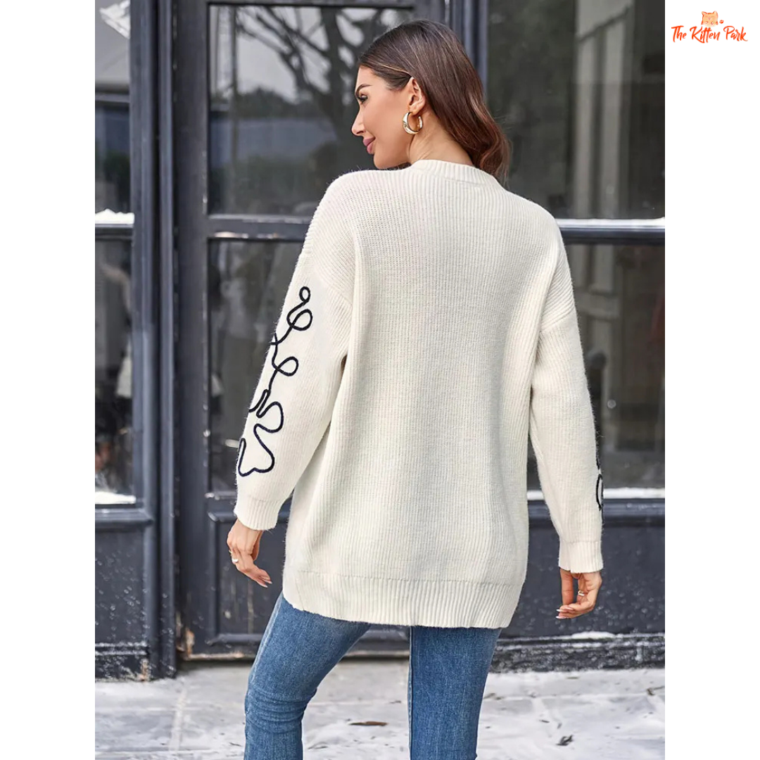Soft beige round-neck pullover sweater for women featuring floral prints, knit texture, and a loose long fit perfect for casual autumn and winter wear.