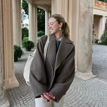 A women’s camel brown double-breasted wool coat with lapel collar, long sleeves, and a loose fit, designed for autumn and winter elegance.