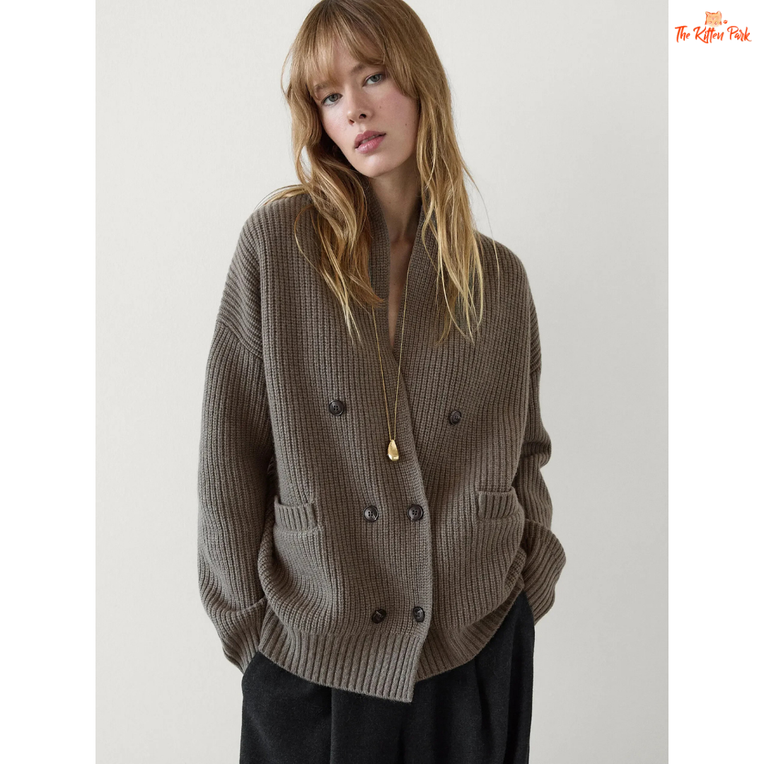 Woman wearing a gray ribbed sweater with a plain background