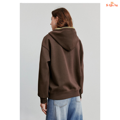 Person wearing a brown hoodie and blue jeans on a plain background