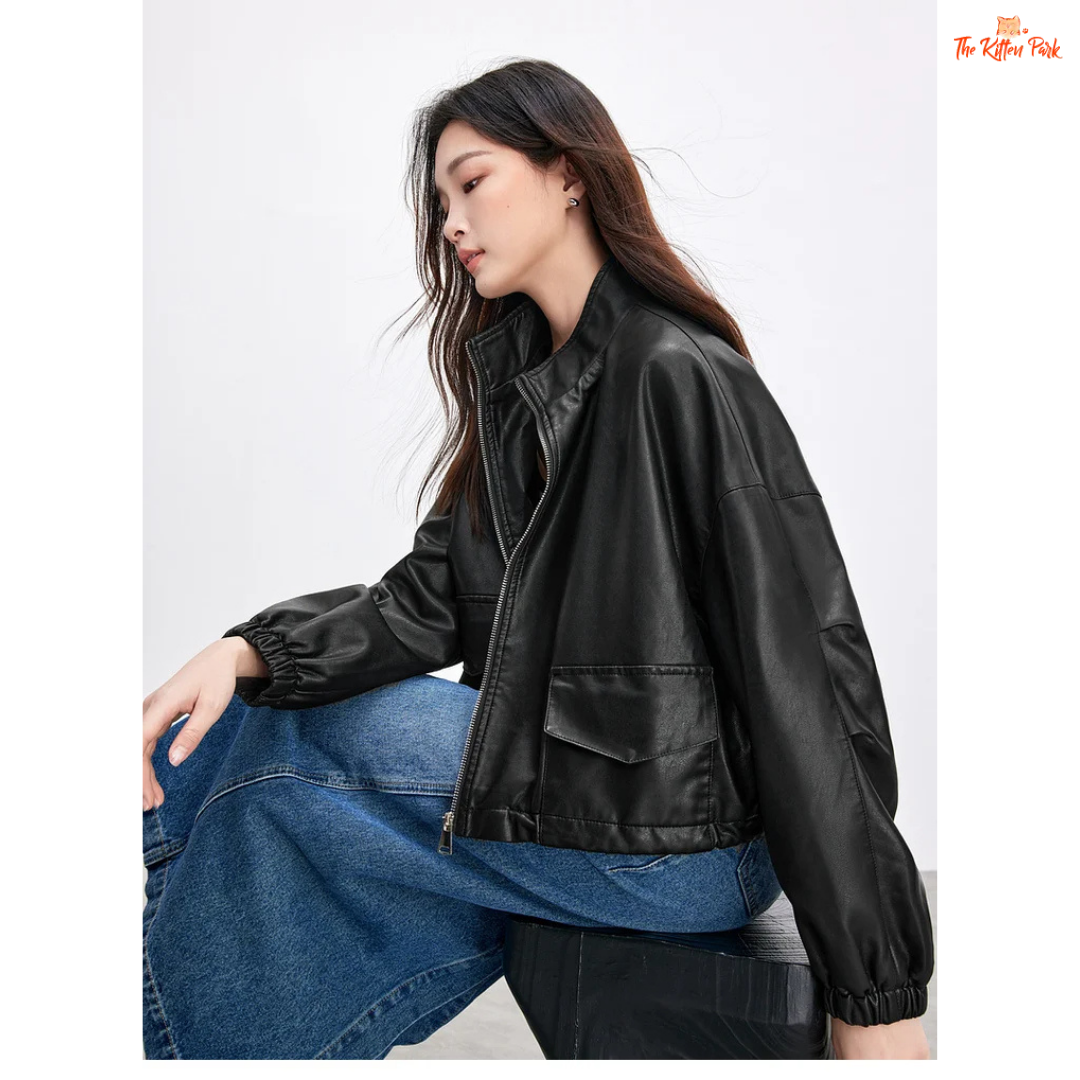 Woman wearing a black leather jacket and blue jeans on a white background