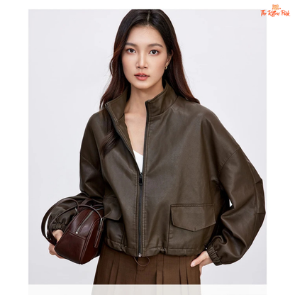 Woman wearing a brown leather jacket holding a brown handbag on a white background