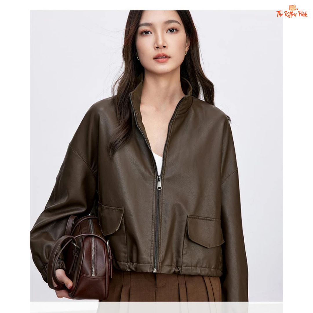 Woman wearing a brown leather jacket holding a matching handbag on a white background