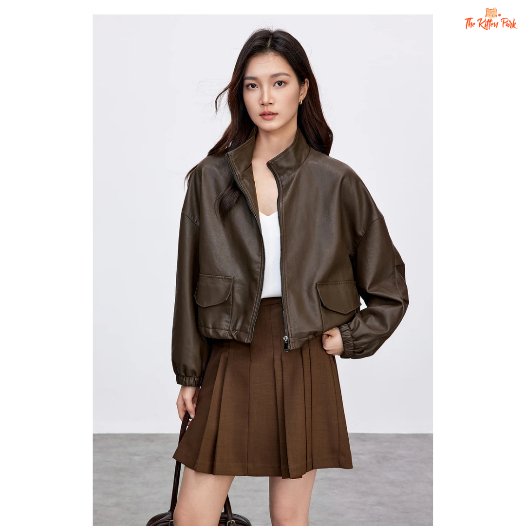 Woman wearing a brown leather jacket and skirt on a white background