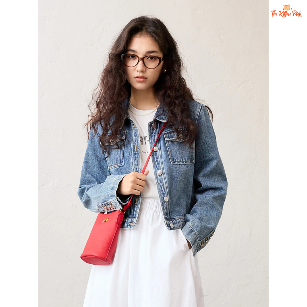 Women’s retro short denim jacket in blue cotton with turn-down collar, single-breasted closure, and buttons, styled for casual spring and summer outfits.