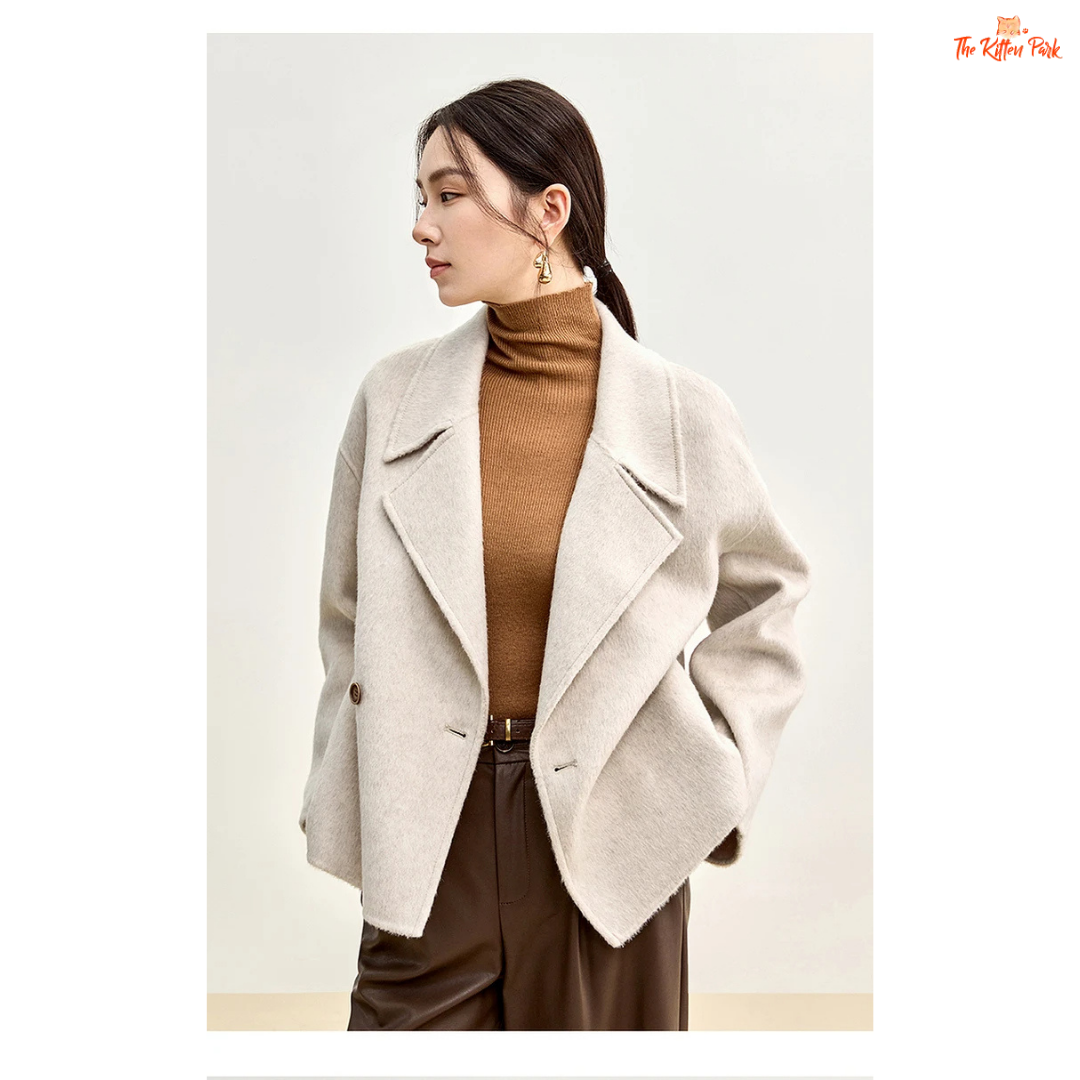 Women’s short wool coat in thick fabric with camel wool blend, double-breasted closure, drop-shoulder sleeves, and turn-down collar for winter wear.