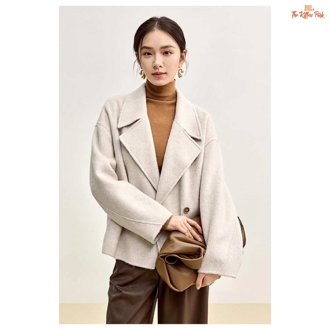 Women’s short wool coat in thick fabric with camel wool blend, double-breasted closure, drop-shoulder sleeves, and turn-down collar for winter wear.