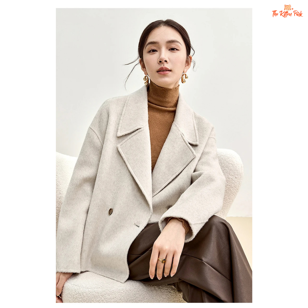 Women’s short wool coat in thick fabric with camel wool blend, double-breasted closure, drop-shoulder sleeves, and turn-down collar for winter wear.