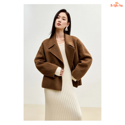 Women’s short wool coat in thick fabric with camel wool blend, double-breasted closure, drop-shoulder sleeves, and turn-down collar for winter wear.