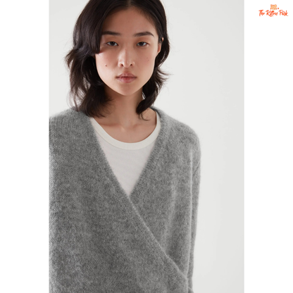 Woman wearing a gray sweater over a white shirt on a white background