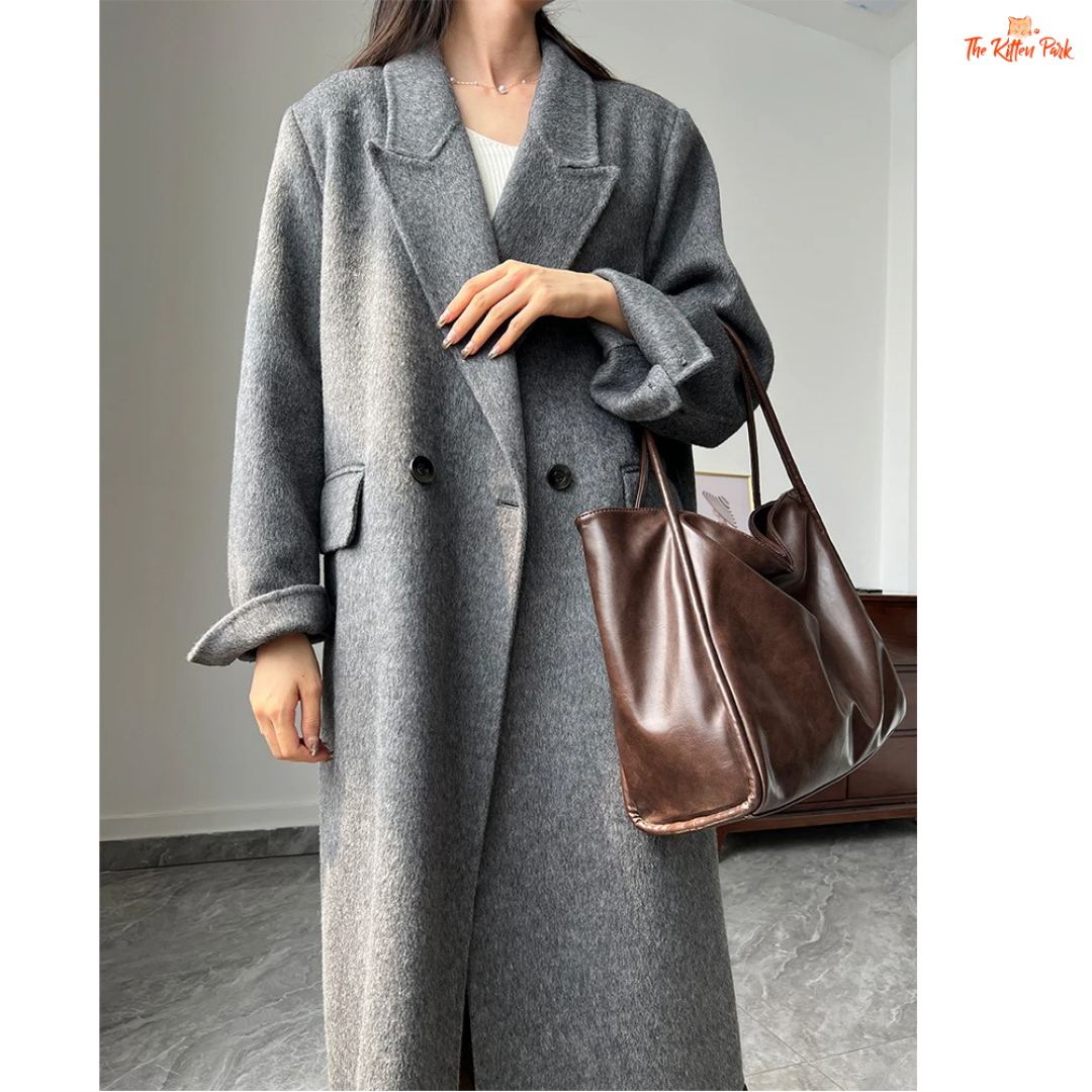 Women’s long wool coat with double-breasted closure, turn-down collar, wide-waisted fit, and button-pocket details in solid design.