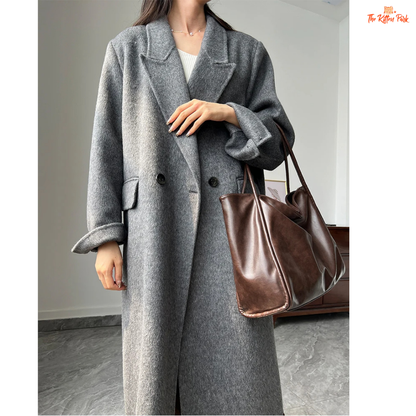 Women’s long wool coat with double-breasted closure, turn-down collar, wide-waisted fit, and button-pocket details in solid design.