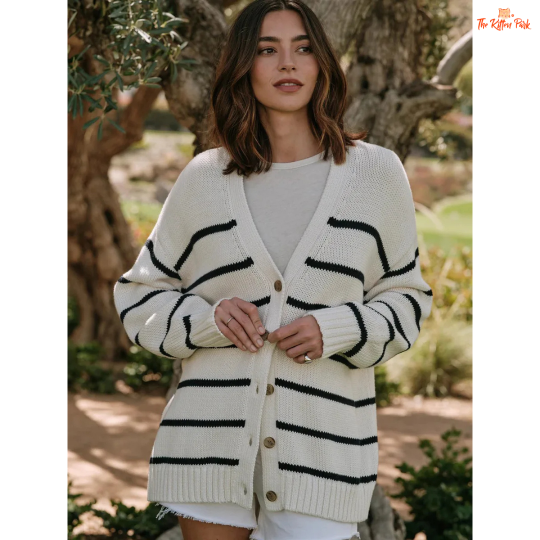 Woman wearing a white cardigan with black stripes outdoors