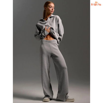 Woman wearing a gray sweater and pants on a plain background