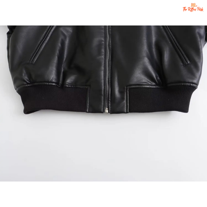 A sleek black PU leather jacket for women with a zippered front, round neck, and long sleeves, styled for modern streetwear fashion.