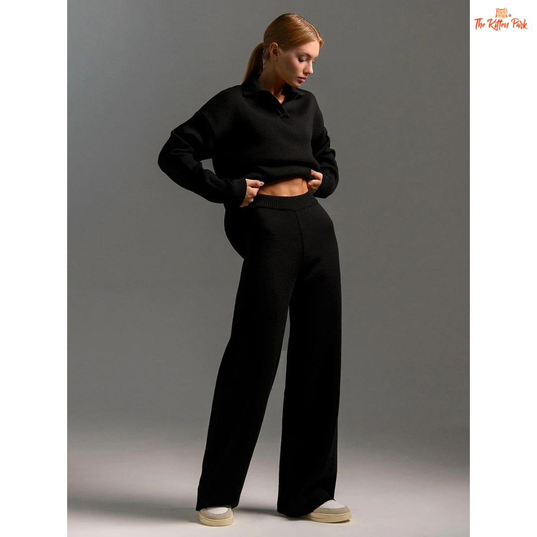 Person wearing a black outfit with wide-leg pants on a gray background